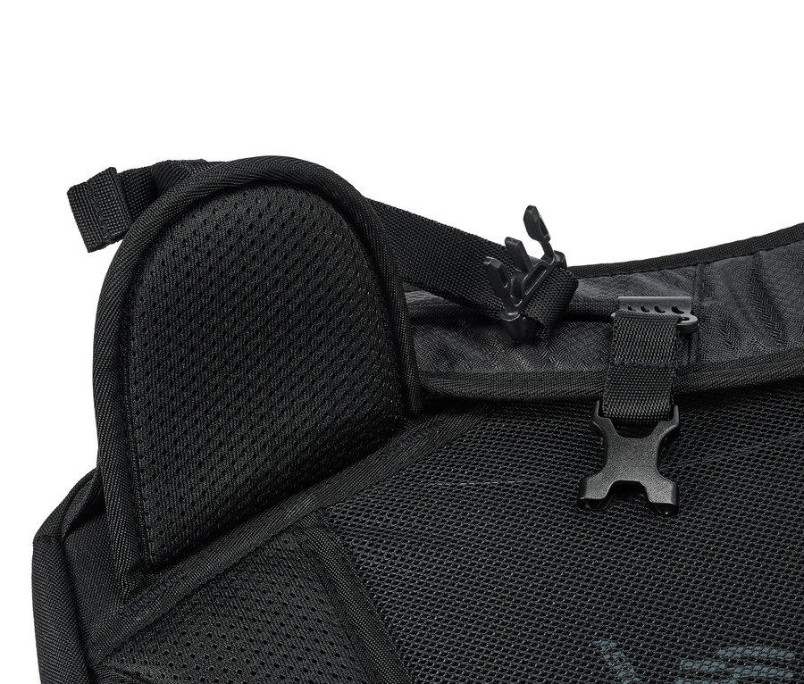 Detailní pohled na černý batoh se síťovanou strukturou a plastovými sponami.