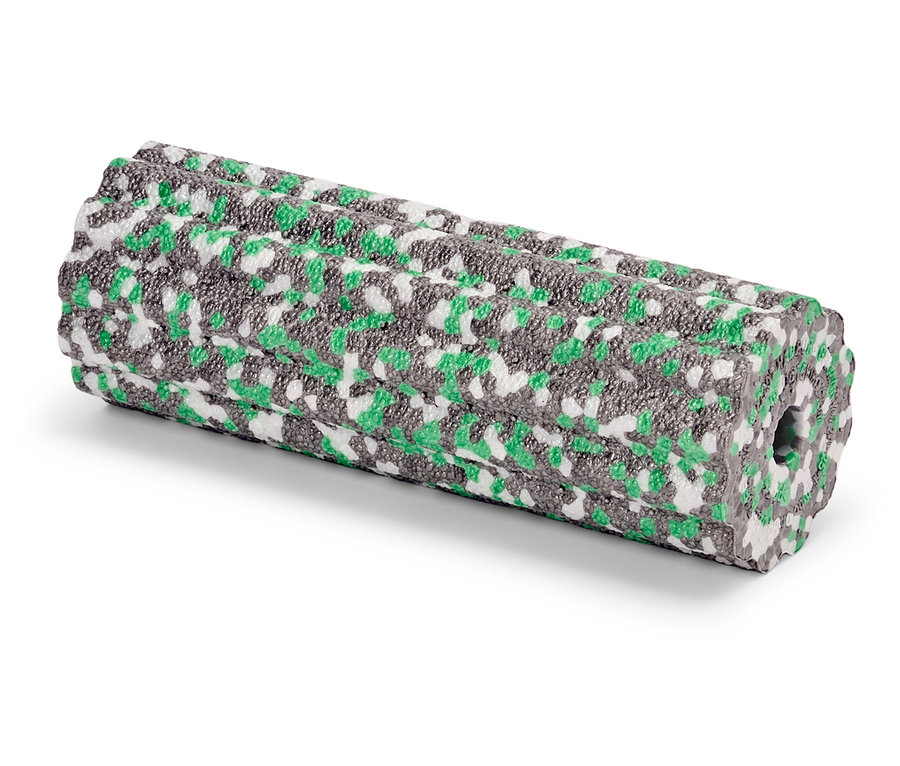 Pěnový váleček se zeleným, šedým a bílým vzorem leží na bílém povrchu.