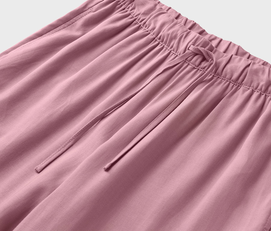 Detailní záběr na růžové kalhoty se stahovací šňůrkou.
