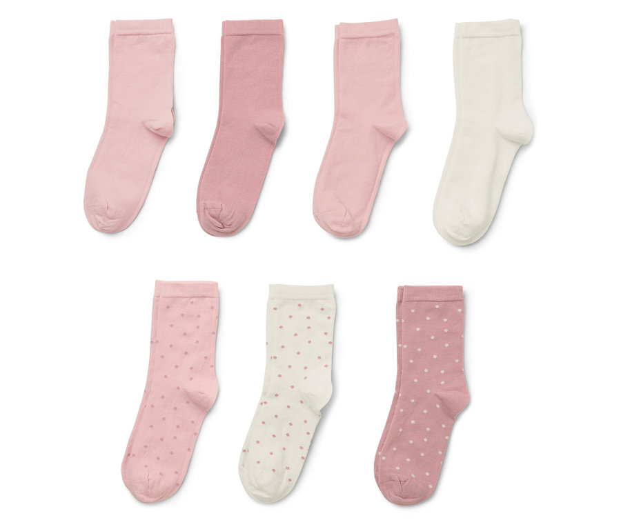 Sedm ponožek v různých odstínech růžové a krémové, některé s puntíky.