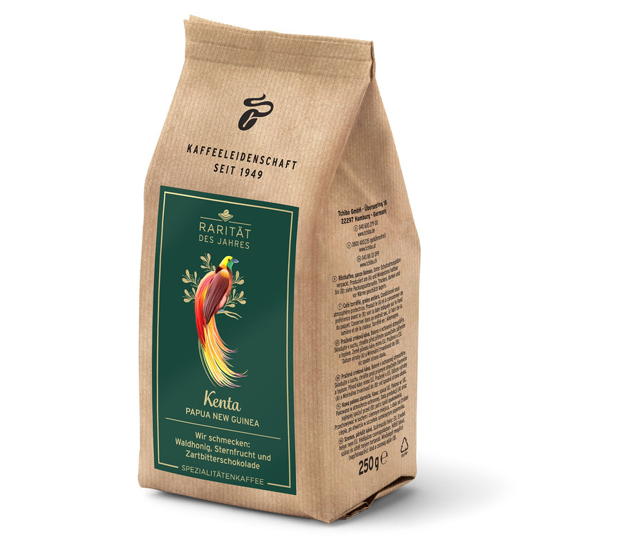 Je vidět hnědý balíček kávy Tchibo "Kenta Papua New Guinea" s obrázkem ptáka.
