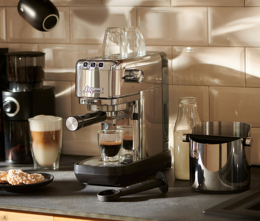 Stříbrný pákový kávovar »Lapressa« na lince připravuje espresso do sklenice.