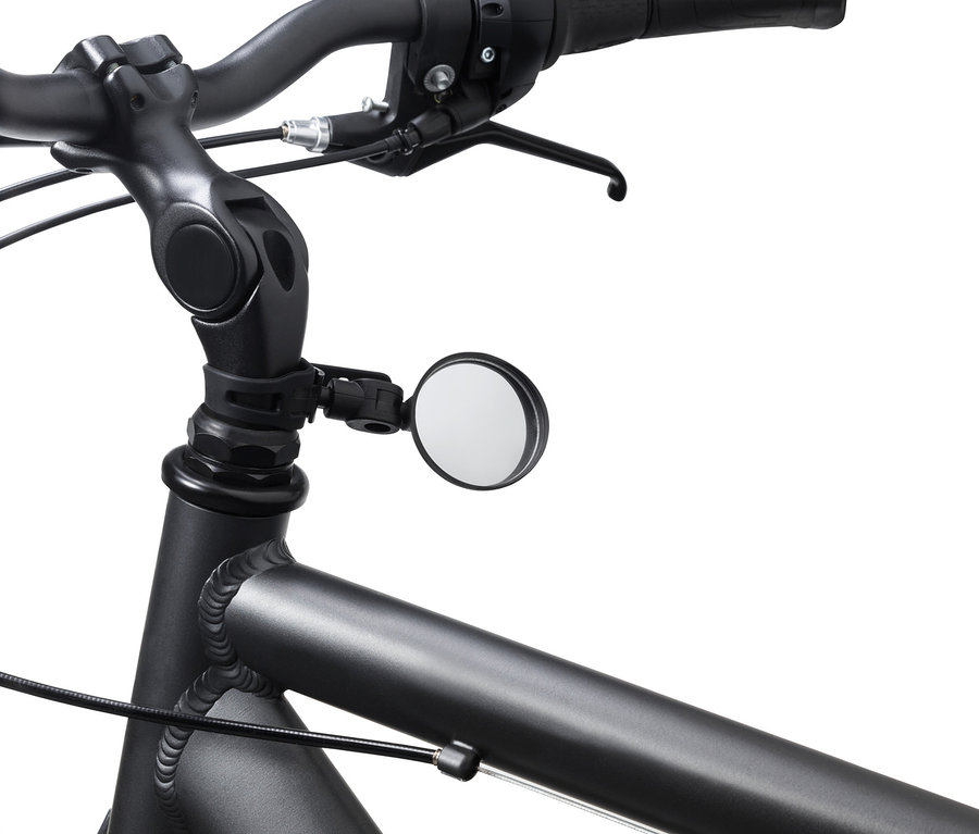 Detail kola s černými řídítky a kulatým zrcátkem na kolo.