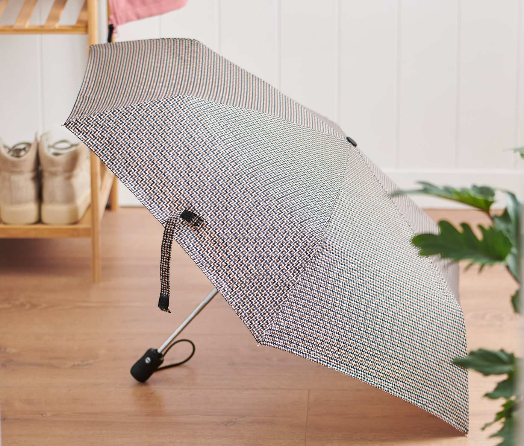 Na podlaze leží složený automatický deštník.