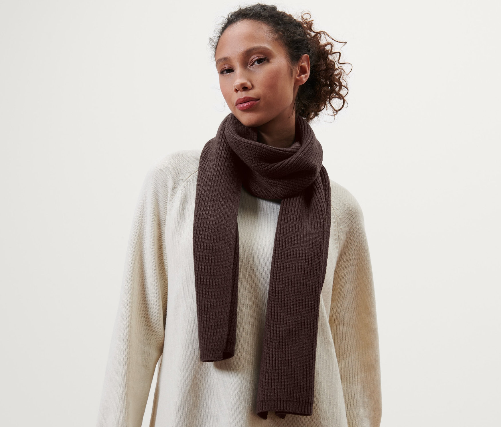 Žena s hnědou pletenou šálou na sobě.