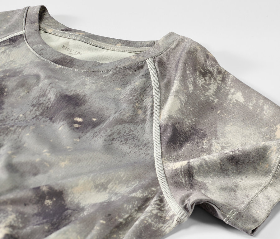 Detail dětského sportovního trička ze sady 2 kusů, zelené s celoplošným potiskem.