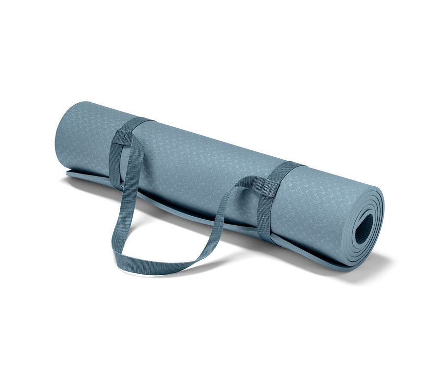 Srolovaná modrá podložka na jógu s popruhy.