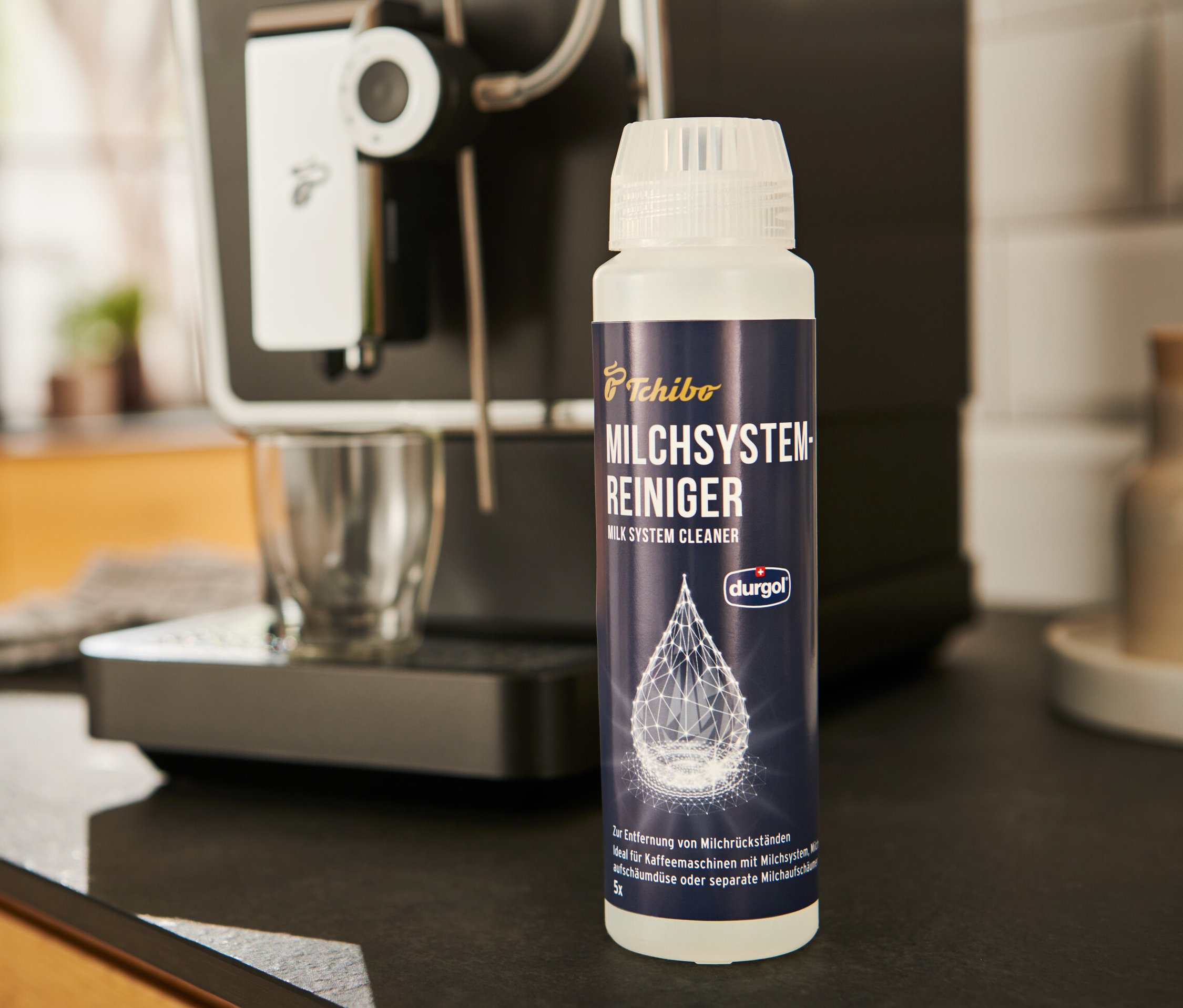 Čistič mléčného systému durgol®	, 250 ml stojí vedle kávovaru.