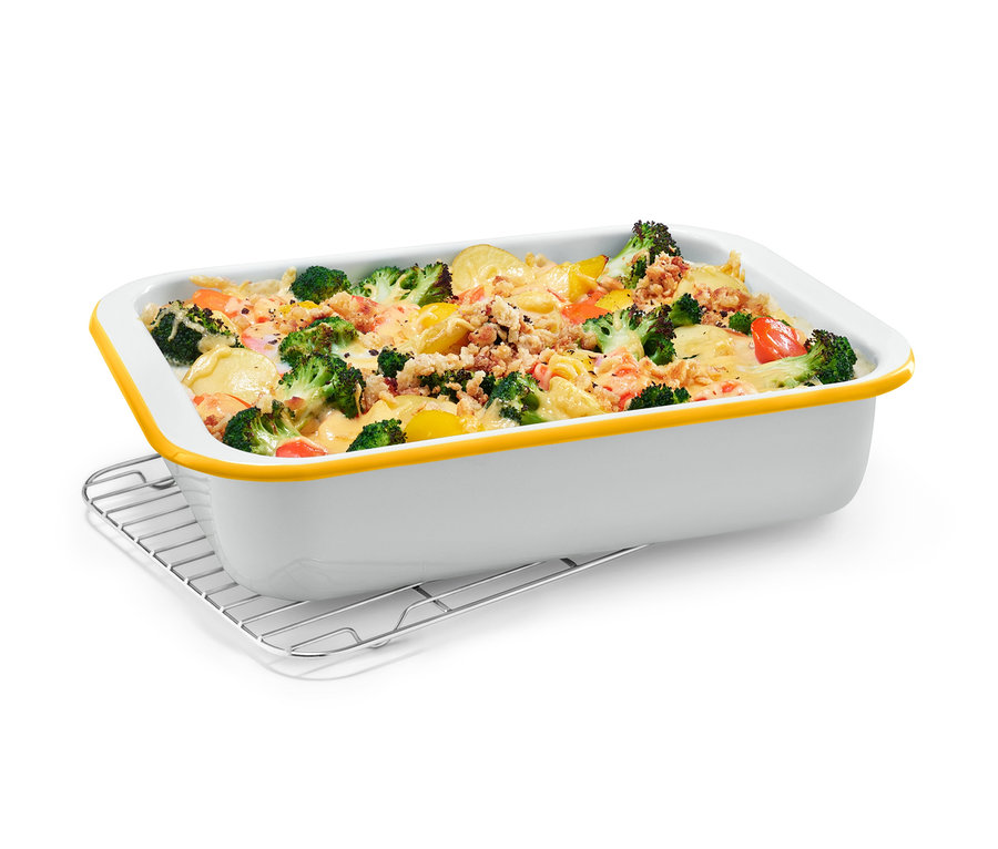 Smaltovaná zapékací forma s mřížkou plná zapečené zeleniny.