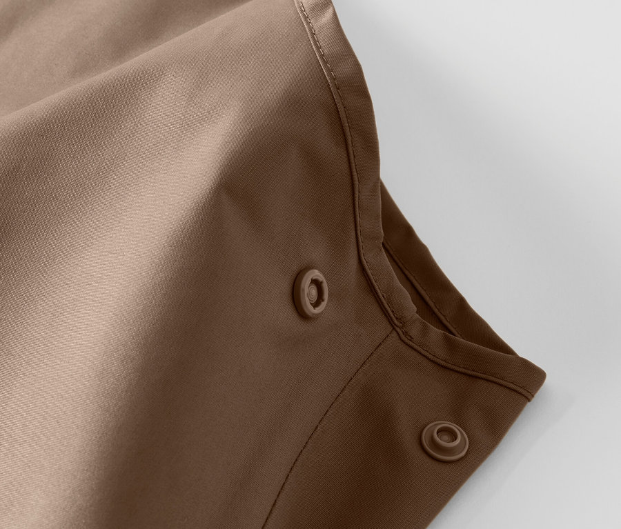 Detail dětských kalhot do deště s patentkami.