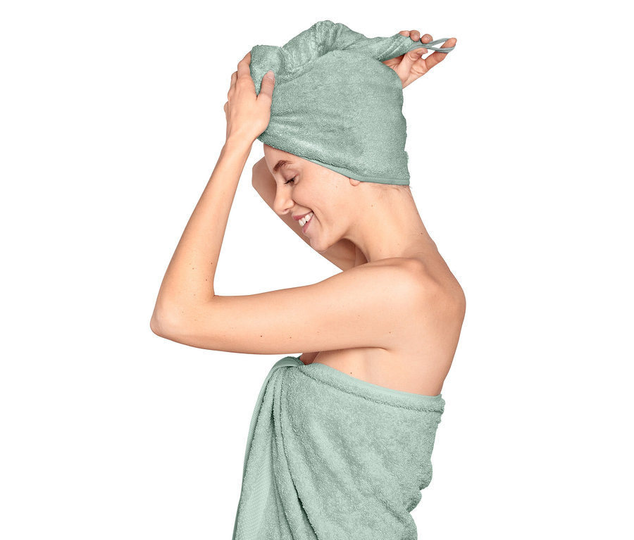 Žena si na hlavu dává světle modrý ručníkový turban.