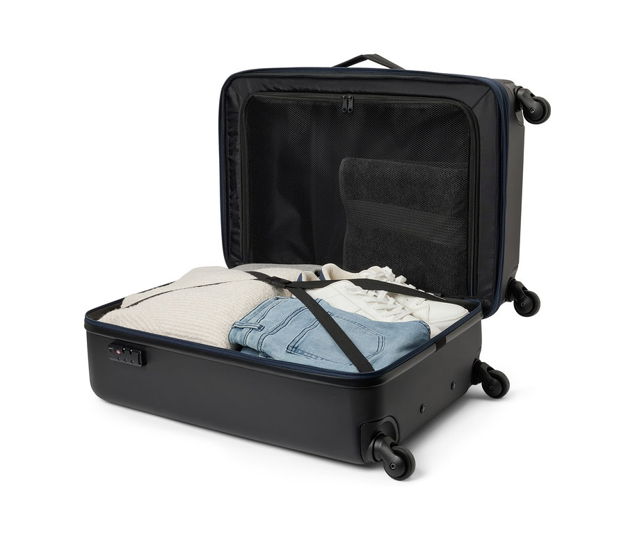 Otevřený hybridní kufr střední velikosti s oblečením uvnitř.