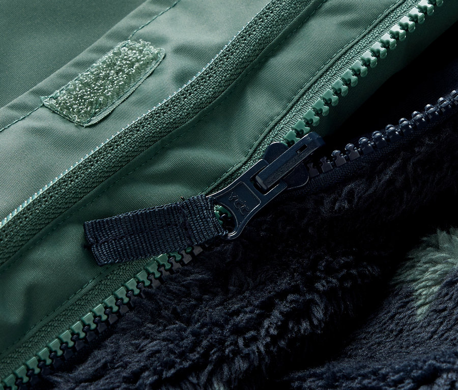 Detailní záběr na zip a suchý zip zelené dětské zimní bundy 3 v 1.
