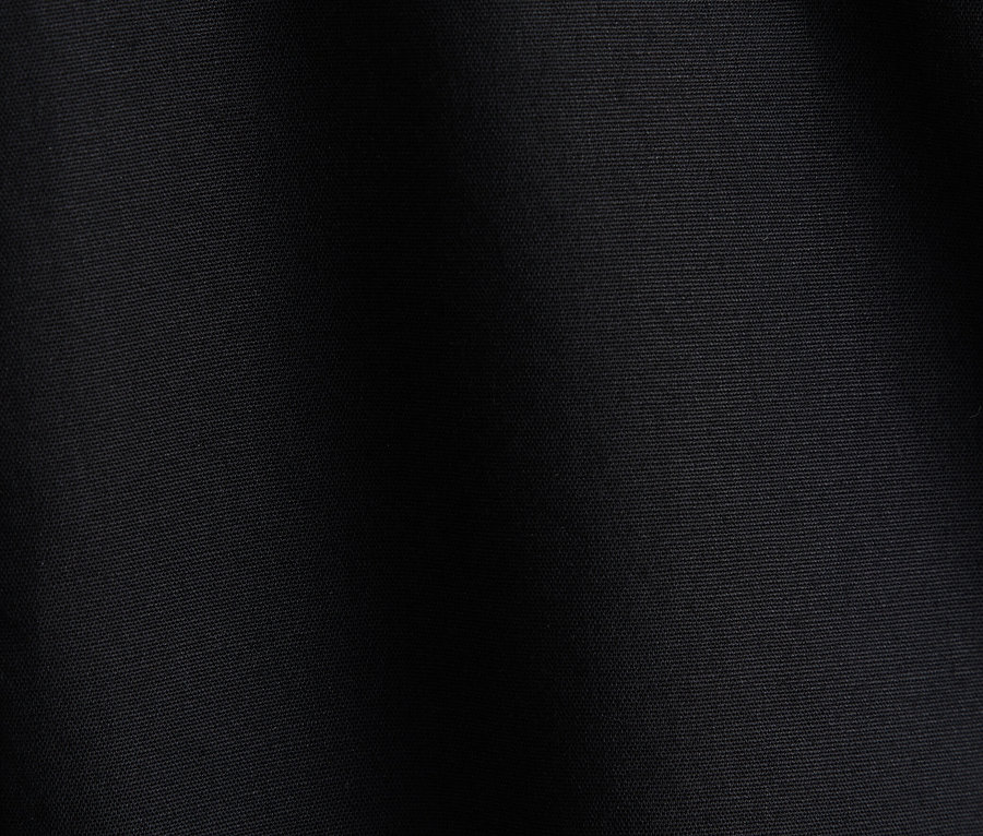 Textura tmavé látky s jemnými záhyby.