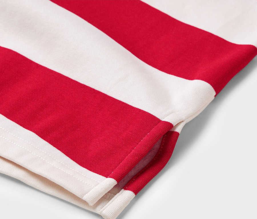 Detail červeno-bílého pruhovaného trička s krátkým rukávem.