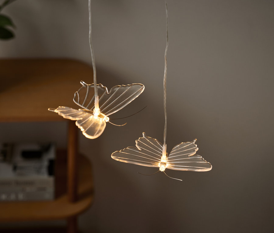 Dvě světla ve tvaru motýlů visí ze stropu.