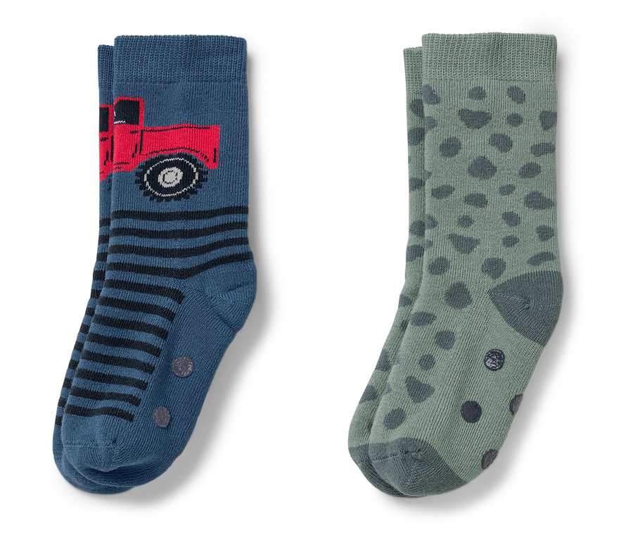 Dva páry ponožek. Jedny modré s červeným náklaďákem a pruhy, druhé zelené s tmavě zelenými puntíky.