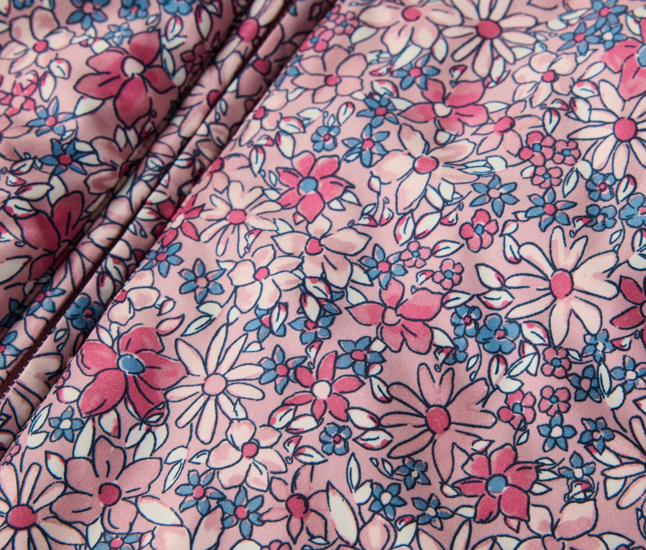 Detail zimního overalu pro miminka s květinovým vzorem.