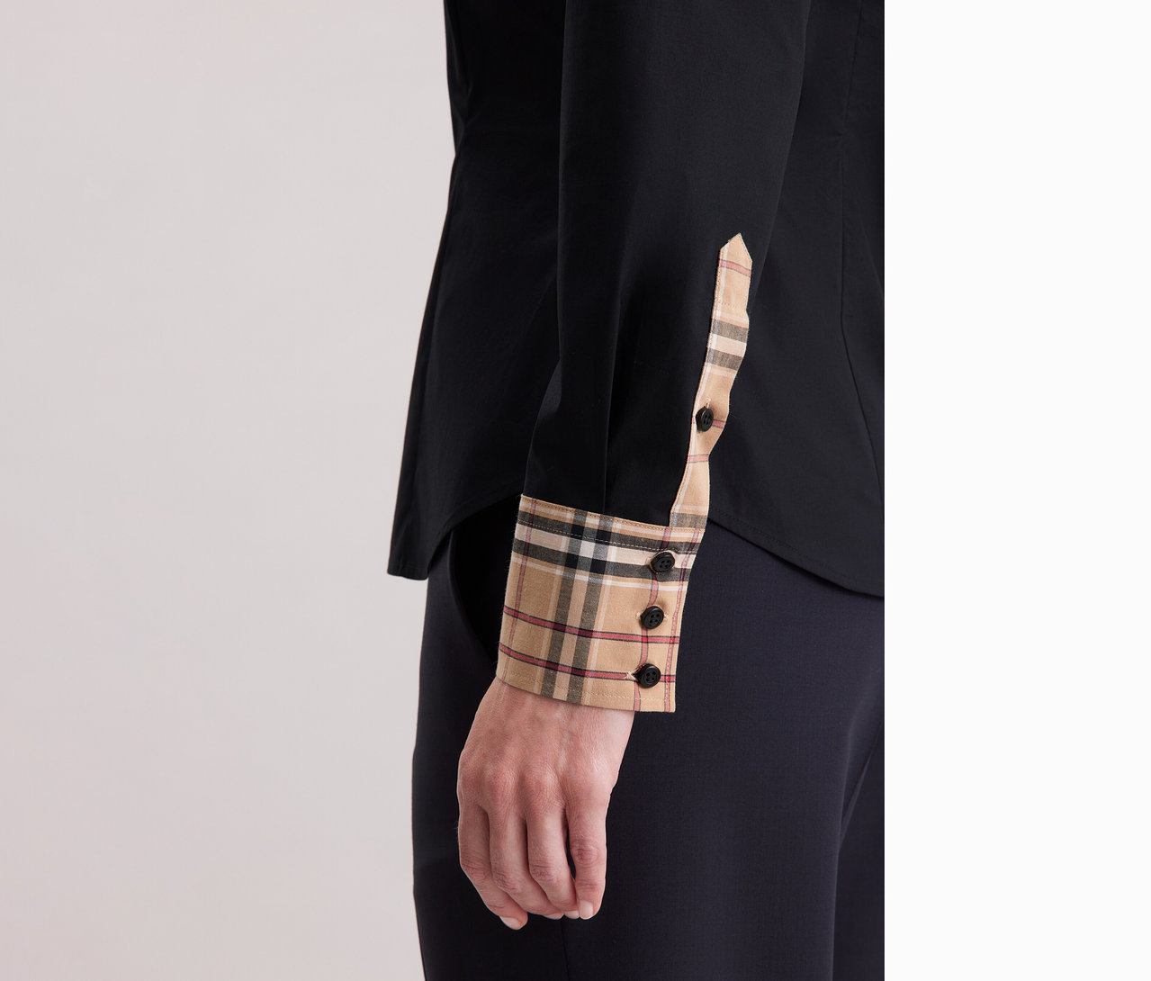 Detailní záběr na ženu v popelínové halence Seidensticker s kostkovaným detailem.