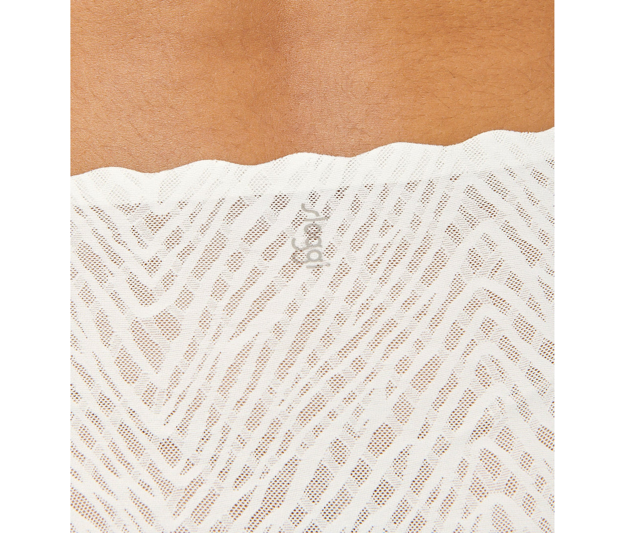 Detailní záběr na osobu v bílých, vysoce vykrojených kalhotkách sloggi ZERO Feel Bliss High leg v barvě silk white s cikcak vzorem.