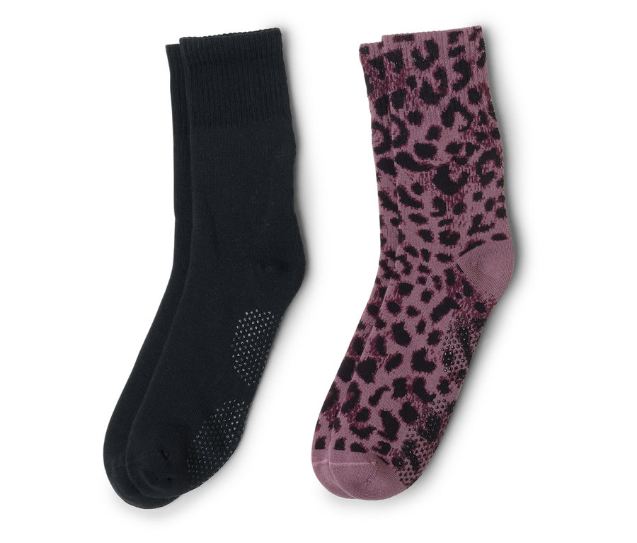 Dvě ponožky leží vedle sebe, jedna černá s výstupky, druhá fialová s černým leopardím vzorem.