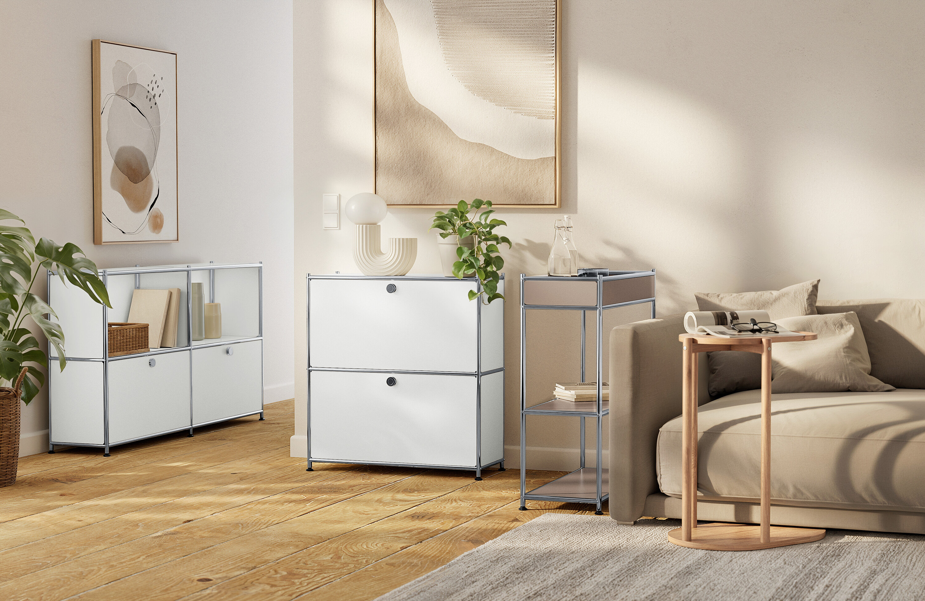 Obývací pokoj s bílými modulárními úložnými jednotkami, béžovou pohovkou a neutrálními uměleckými díly.