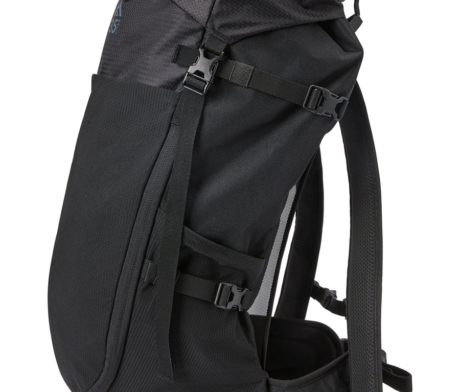 Detailní záběr černého batohu s popruhy a sponami.
