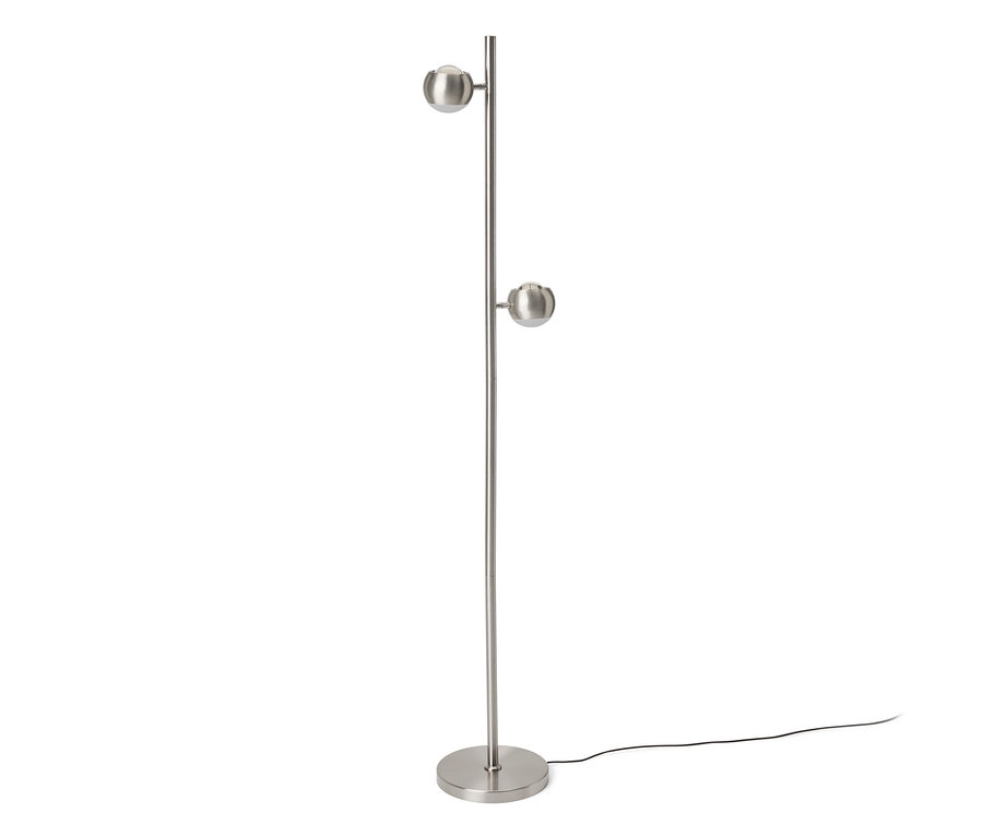Stříbrná stojací lampa s kulatou základnou a dvěma kulovitými svítidly na vysoké tyči. Černý napájecí kabel leží na podlaze.