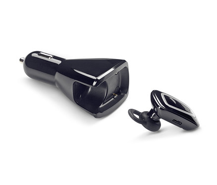 Černá handsfree sada do uší s USB nabíječkou do auta leží na bílém pozadí.