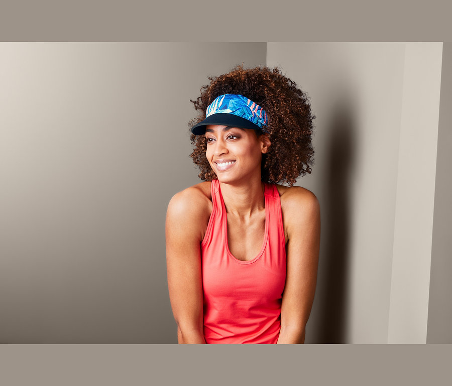 Žena s afro účesem nosí kšilt 2 v 1.