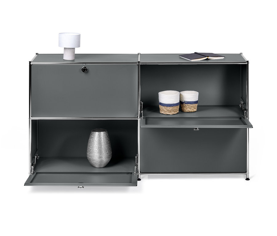 Šedá odkládací skříňka »CN3« se 4 výklopnými dvířky. Dva páry dvířek jsou zavřené, dvoje otevřené a v nich váza a dva košíky.