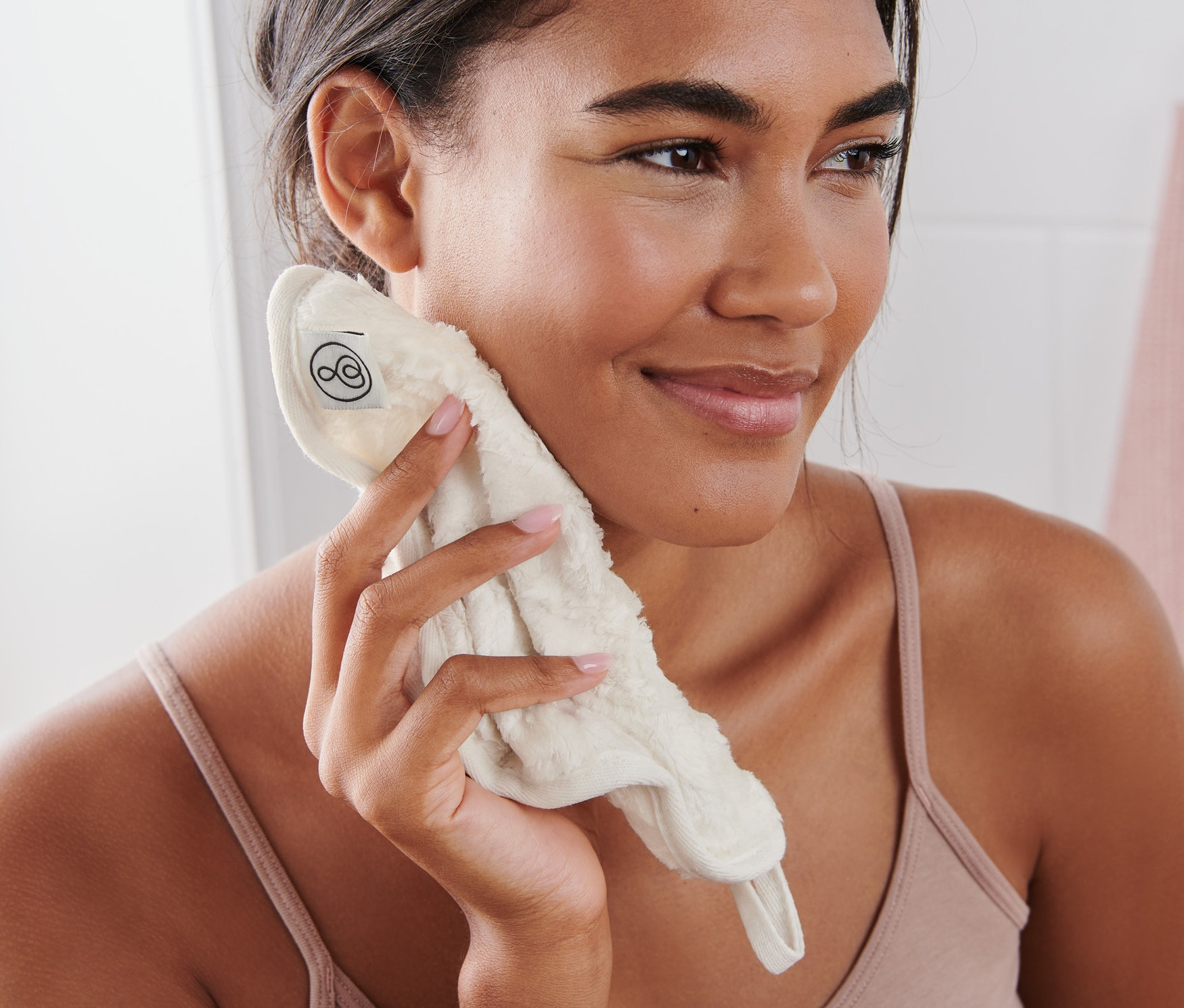 Žena si čistí obličej kosmetickým ručníkem.