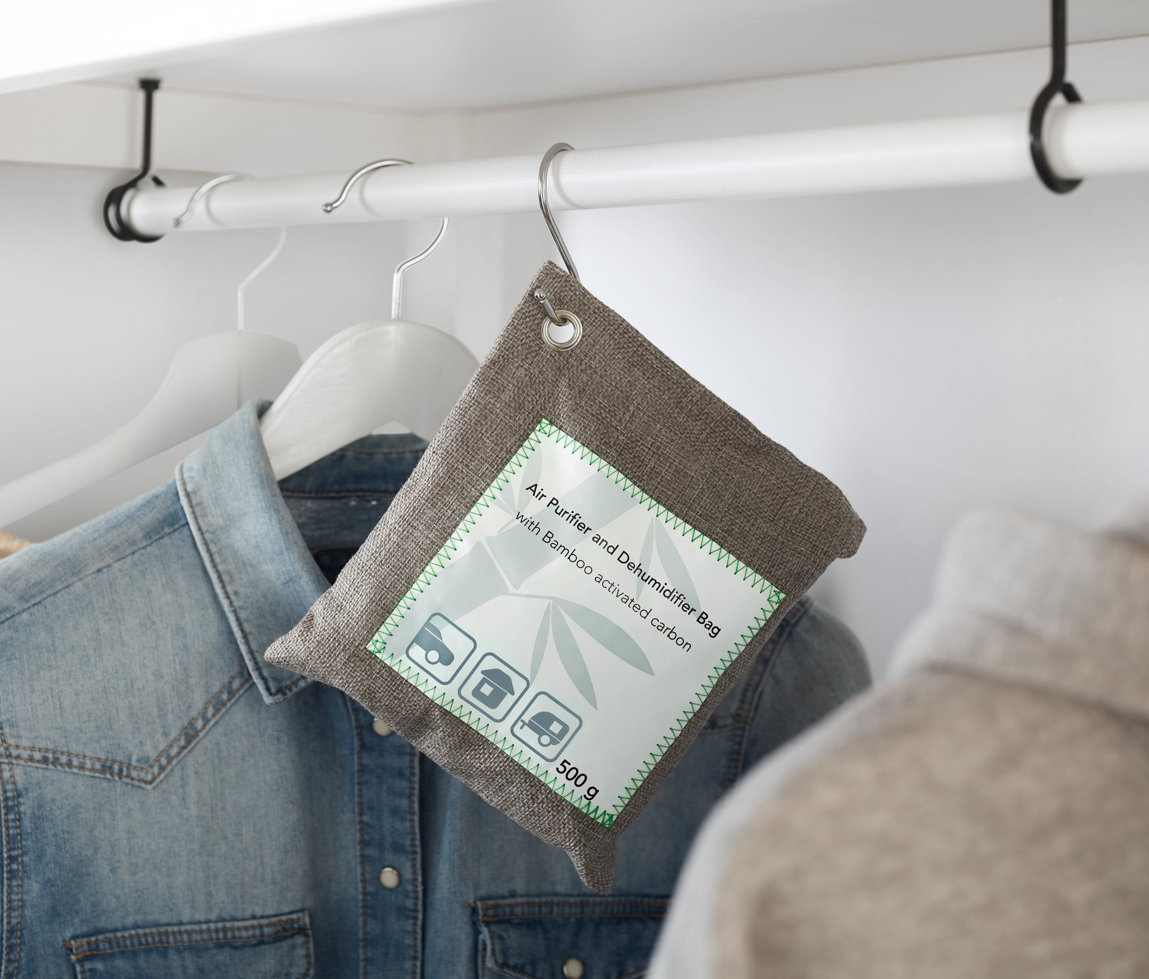 Hnědý Polštářek na čištění vzduchu a odvlhčování visí na ramínku v šatníku.