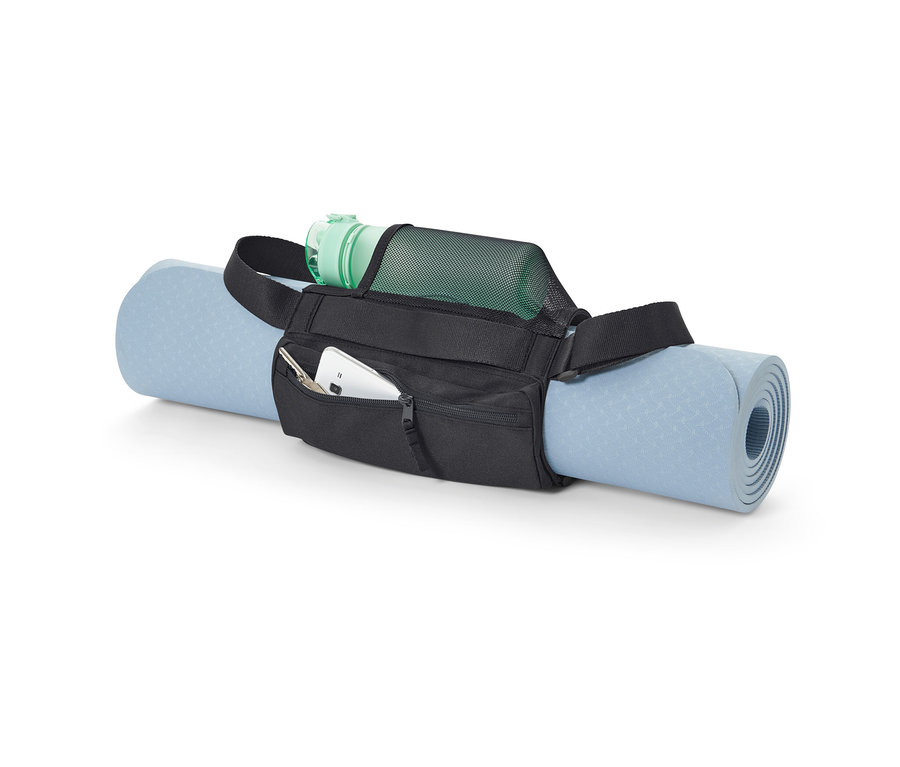 Modrá podložka na cvičení je upevněna popruhem na přenášení podložky černé barvy. V kapse popruhu je mobilní telefon a klíče a v síťované kapse je zelená láhev s vodou.