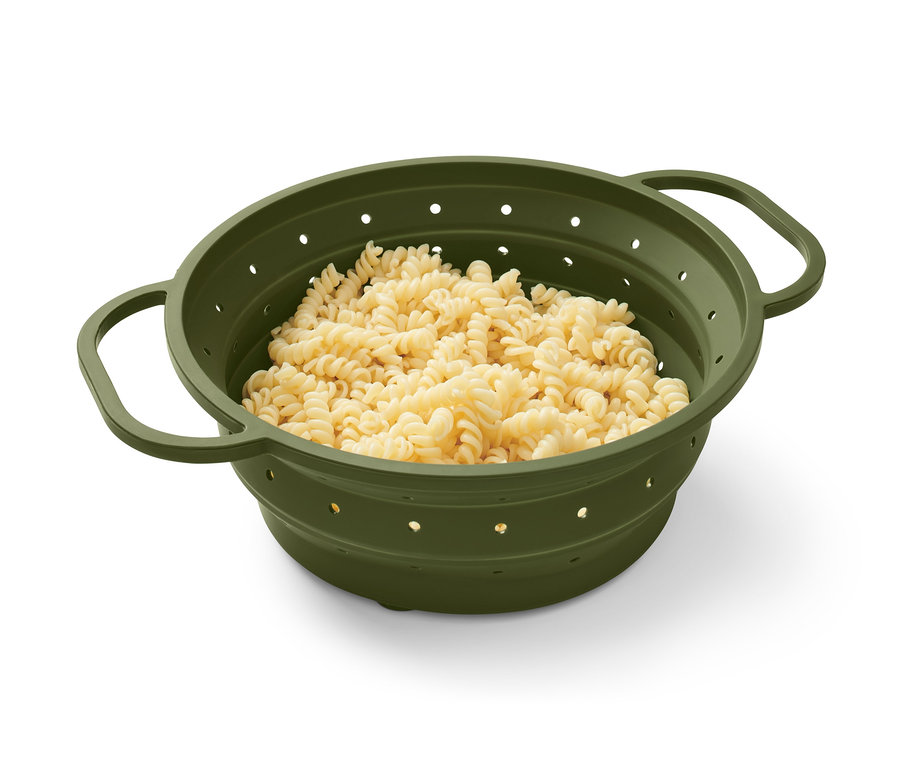 Fusilli těstoviny v zeleném prostorově úsporném cedníku.