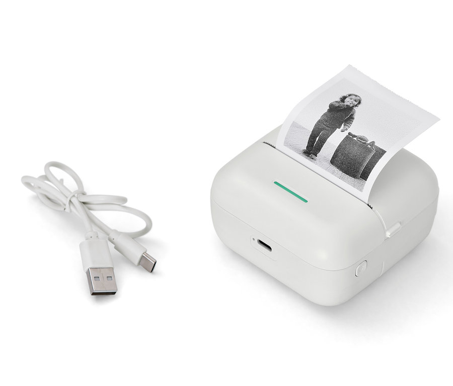 Bílá mini termotiskárna s vytištěnou černobílou fotografií a USB kabelem.
