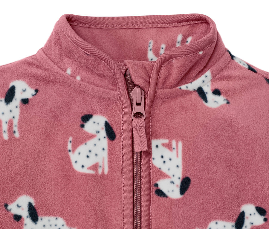 Detail růžové dětské fleecové bundy s potiskem dalmatinů a zapínáním na zip.