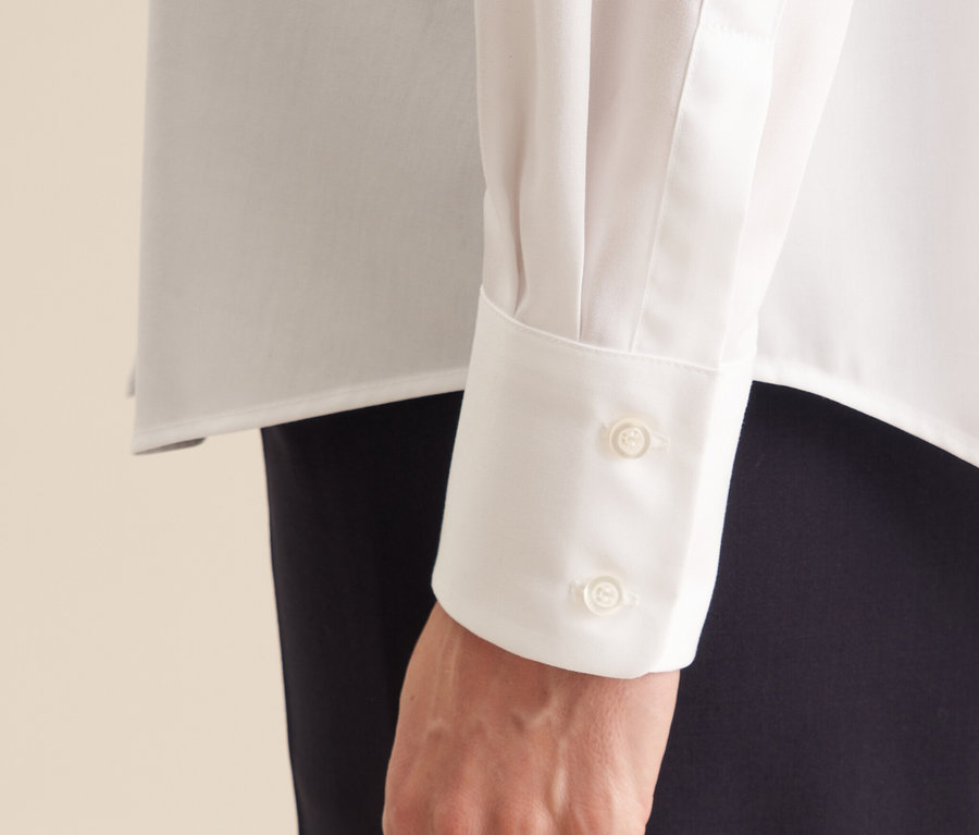 Detail ruky v nežehlivé halence Seidensticker s dvěma knoflíky na manžetě.