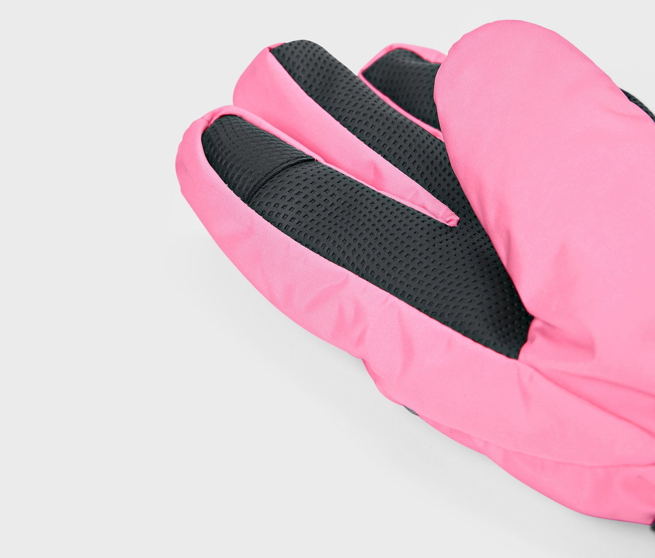 Detail růžové rukavice s černou texturou dlaně.