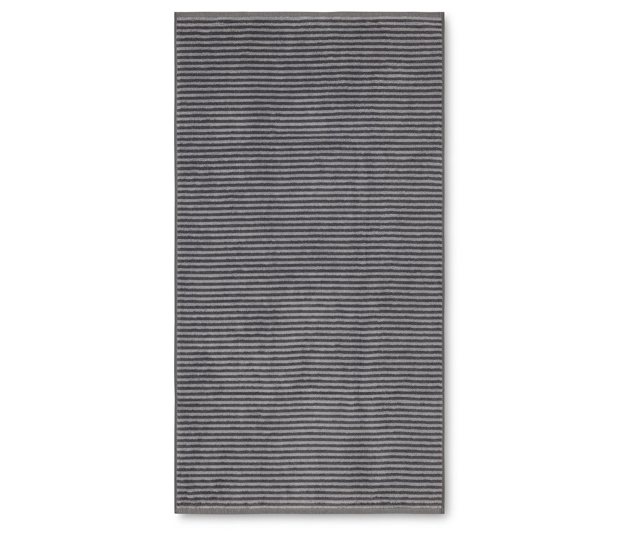 Obdélníkový koberec s vodorovnými pruhy v odstínech šedé a stříbrné leží na bílém pozadí.