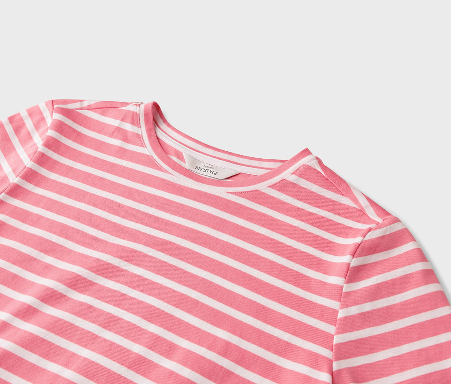 Detail růžovo-bílého trička s horizontálními pruhy.