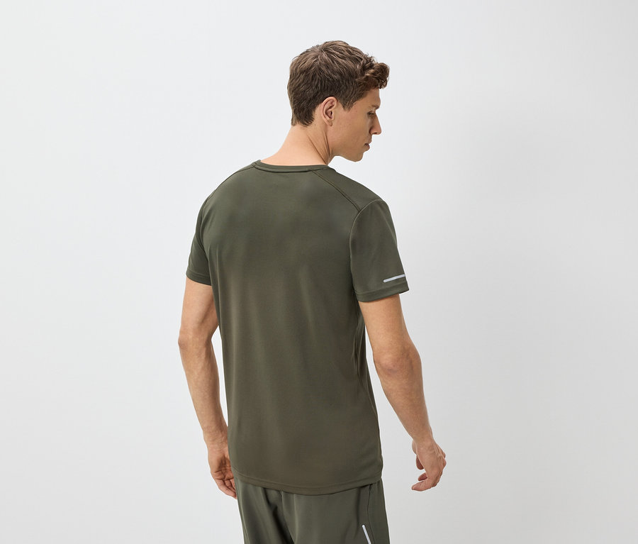 Muž zezadu, má na sobě zelené tričko a kraťasy.