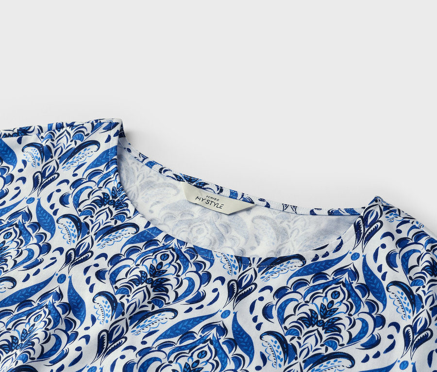 Detailní záběr vrchního oděvu s modrobílým vzorem.