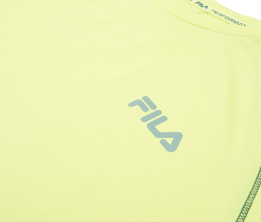 Detailní záběr na světle žlutý sportovní top Fila s modrým logem Fila.