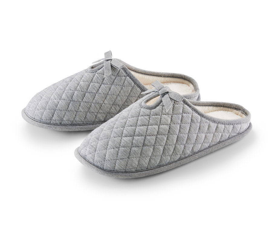 Dvoje šedé prošívané pantofle.