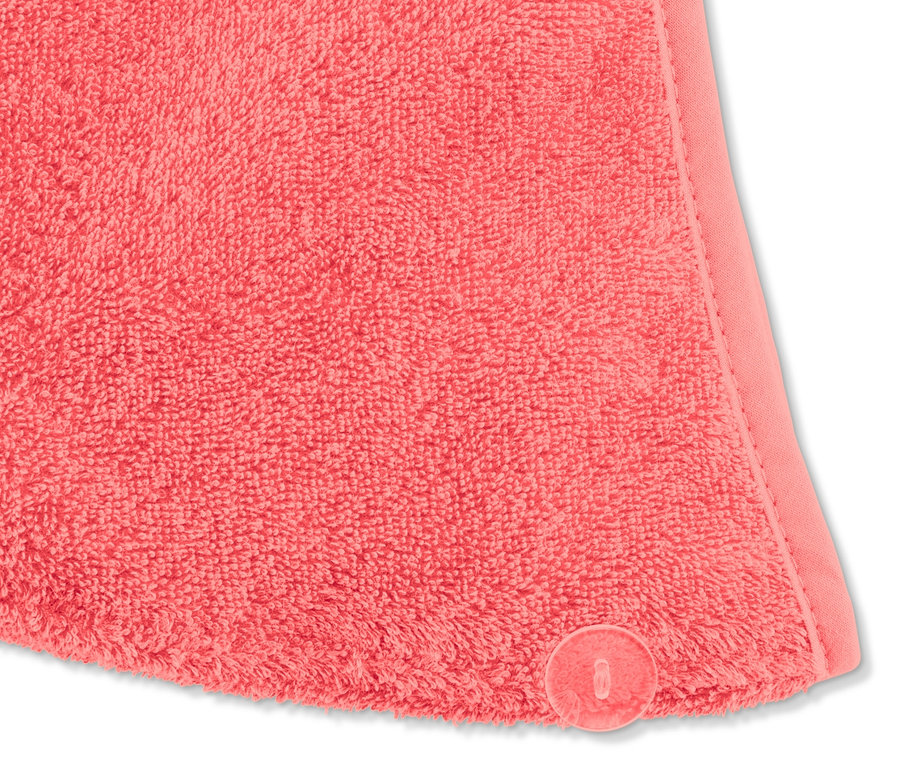 Detail růžového ručníkového turbanu s knoflíkem.