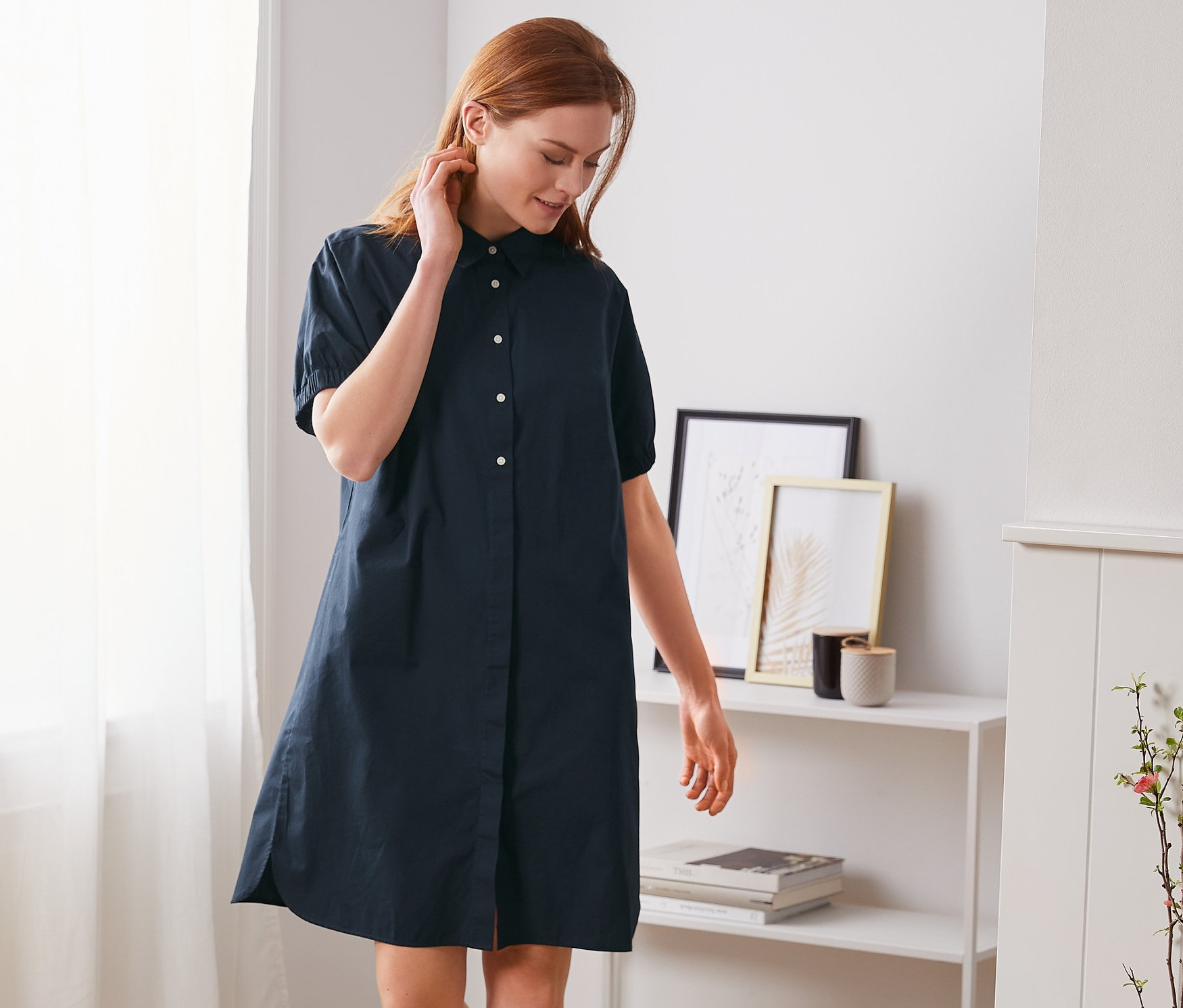 Žena kráčí a má na sobě košilové šaty ve stylu oversized.