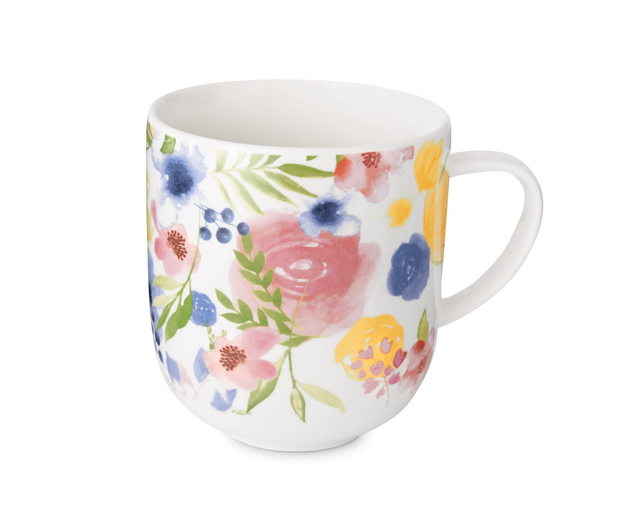 Bílý hrnek s květinovým vzorem.