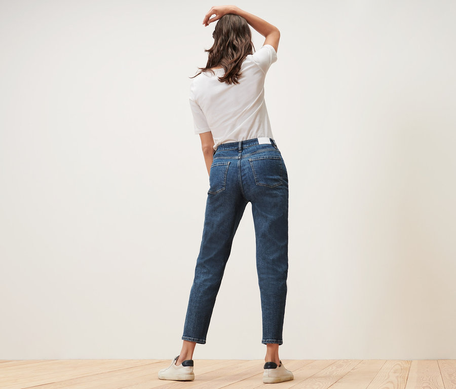 Žena pózuje v džínách Mom – Fit »Nyla« a bílém tričku.