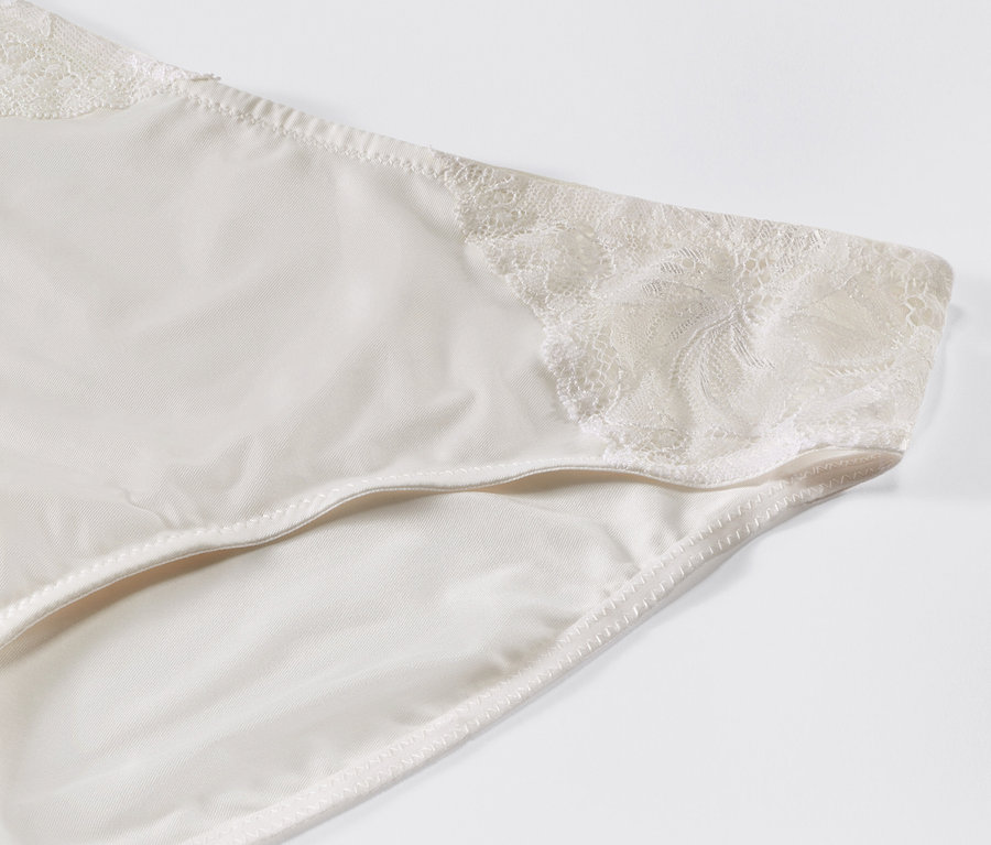 Detail krémových kalhotek s krajkou.